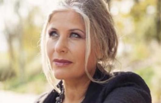blonde spirituele vrouw in zonnige omgeving met diepe blik kijkend naar de toekomst