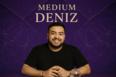 medium Deniz zittend voor een paars spiritueel patroon, met een warme glimlach en een rustige uitstraling