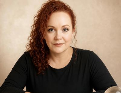 Medium Sarah aan een spirituele tafel met Lenormand kaarten, kristallen bol en warme verlichting. Liefdesmedium en paragnost gespecialiseerd in zielsc